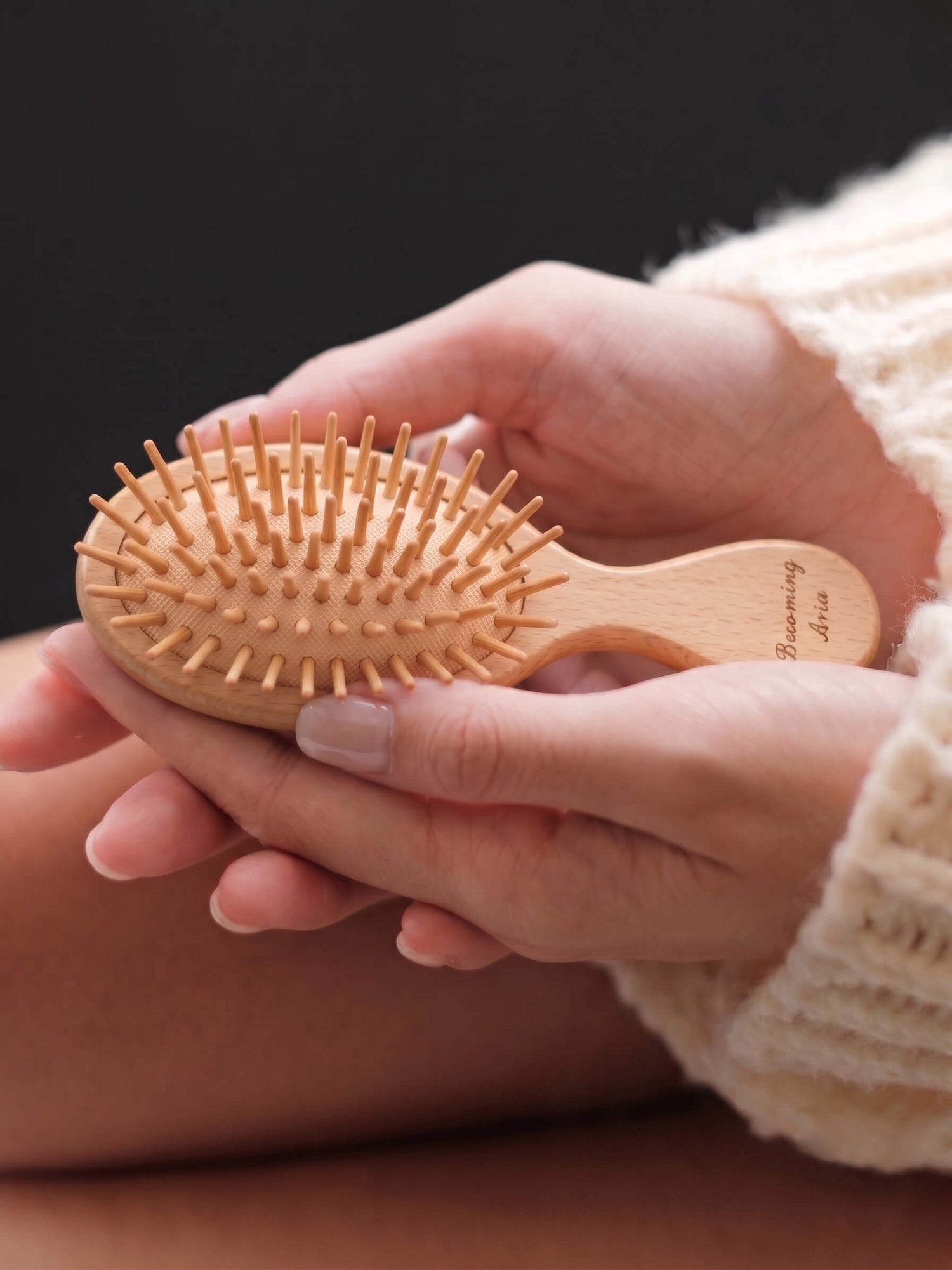 Close up of bespoke engraved wooden hairbrush with becoming aria HERRITE